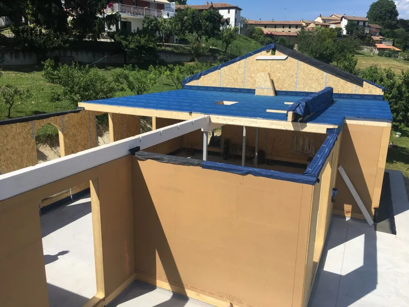 Cantiere EdilAZ: pareti a telaio in legno montate su una platea, con il solaio posato e la membrana impermeabile stesa