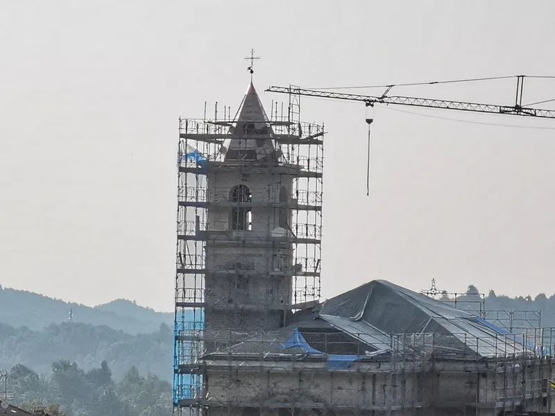 Campanile con il ponteggio EdilAZ e il braccio della gru nella luce del mattino